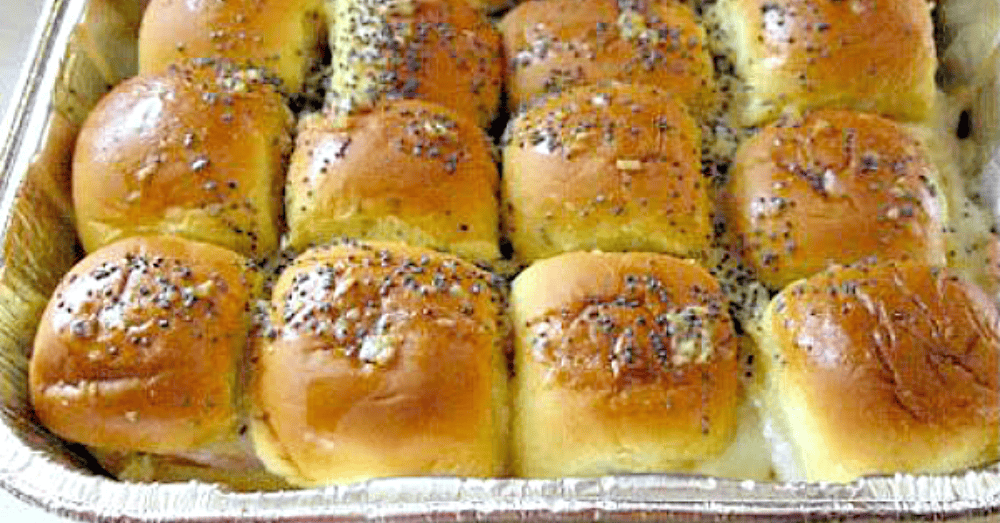 Golden brown dinner rolls topped with poppy seeds, perfectly baked and ready to serve.