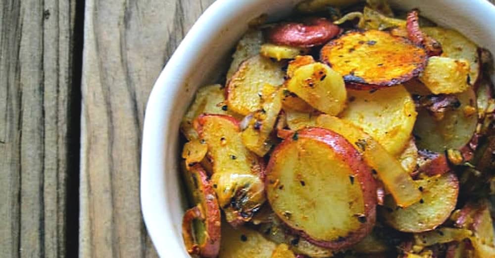 Golden crispy sautéed potatoes topped with fresh herbs and spices, perfect for any meal.