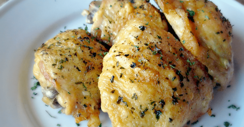 Crispy oven-fried chicken thighs garnished with fresh herbs, perfect for any meal.