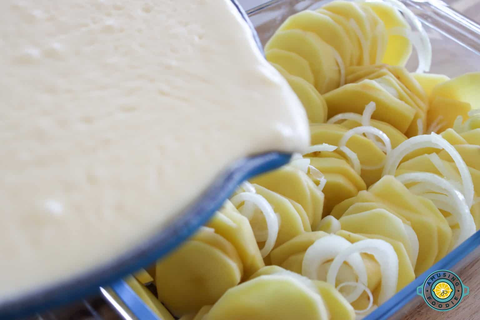 Pouring Cheese Sauce on potatoes and onion