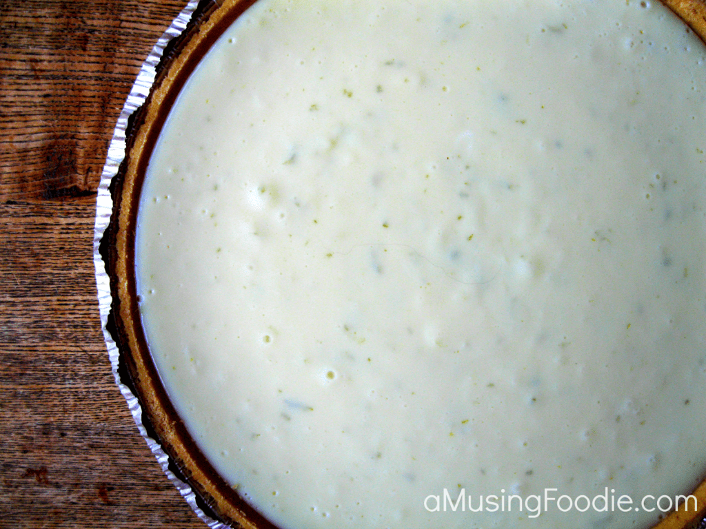Homemade key lime pie cooling in a graham cracker crust, just before the sour cream topping and fresh lime zest is added.