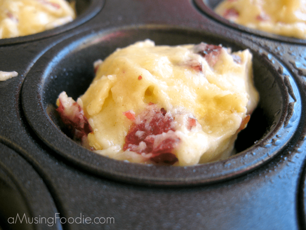 Cranberry almond zucchini muffin batter scooped in mini muffin tin.