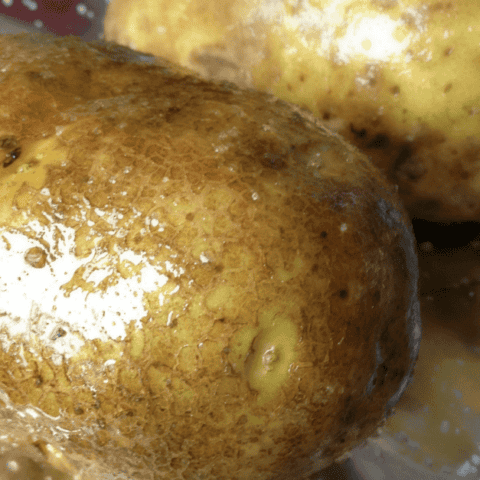 Rustic potatoes on foil, ready for baking and seasoning for delicious, comforting flavor.