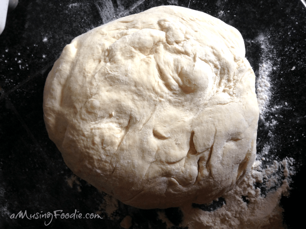 Bun dough on a dark tabletop.