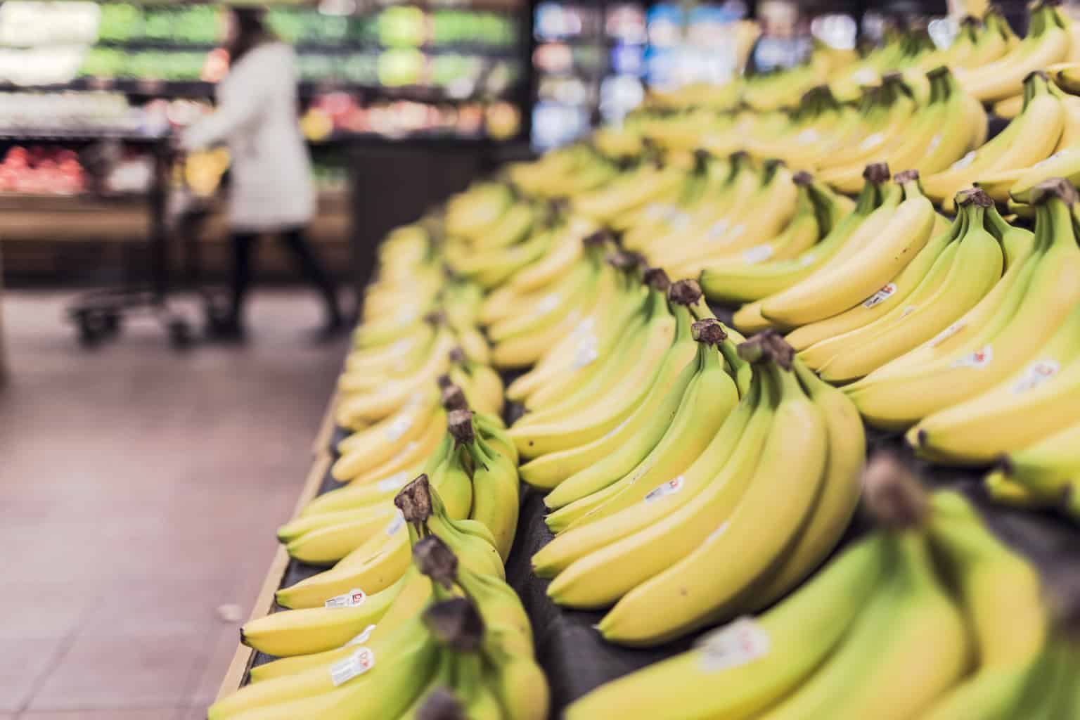 Fresh, vibrant bananas inviting shoppers in a busy grocery store setting.