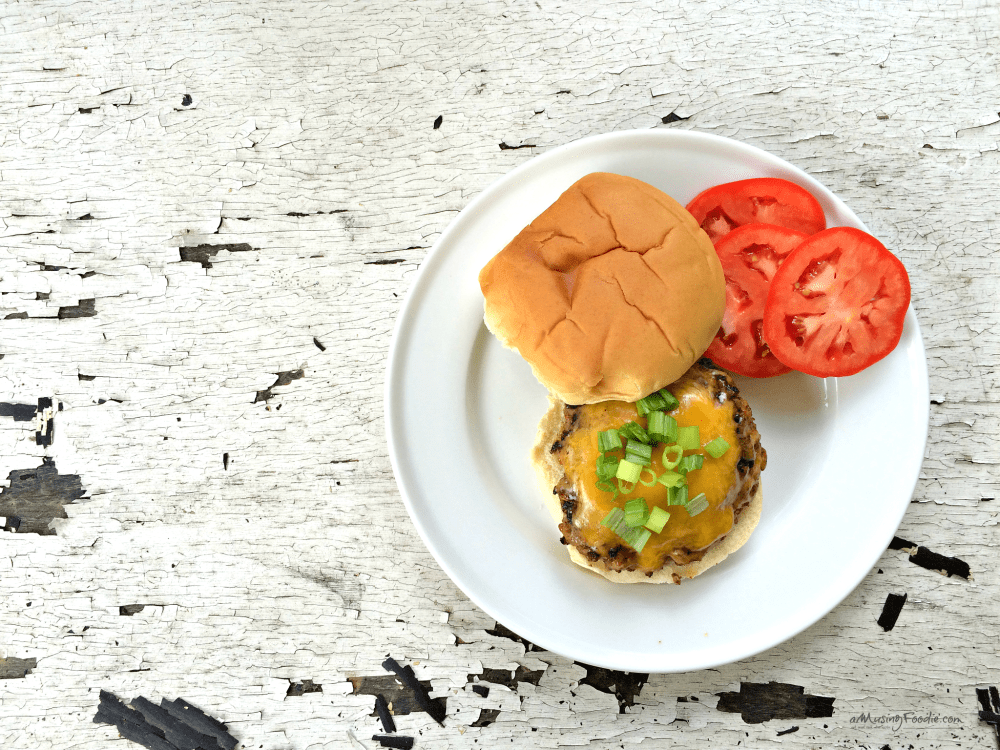 Mouthwatering cheeseburger with fresh toppings on a rustic plate, perfect for burger lovers.