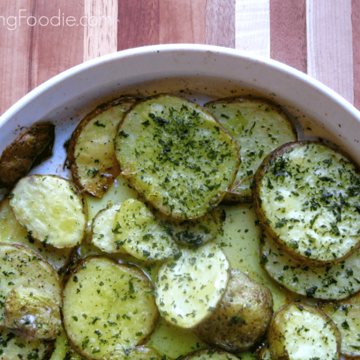 Savory golden roasted potato slices topped with vibrant herbs in a rustic setting.