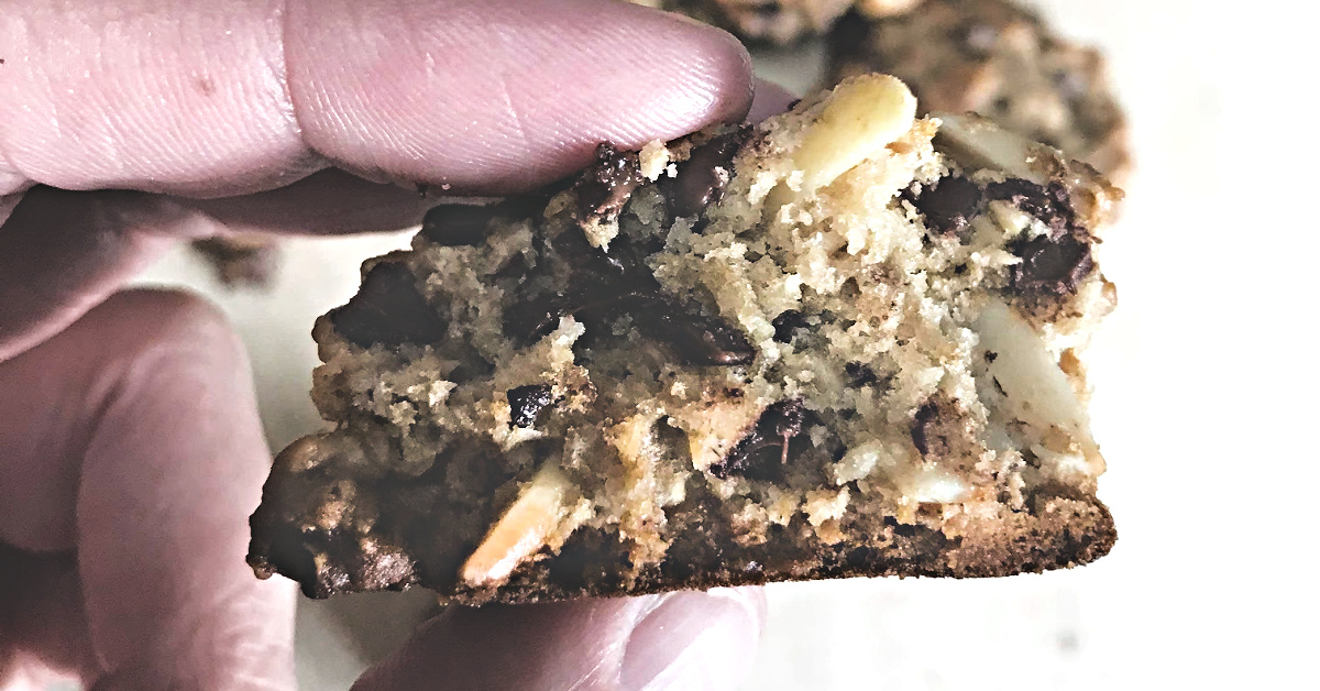 Close-up of a chewy oatmeal chocolate chip cookie bite with almonds.