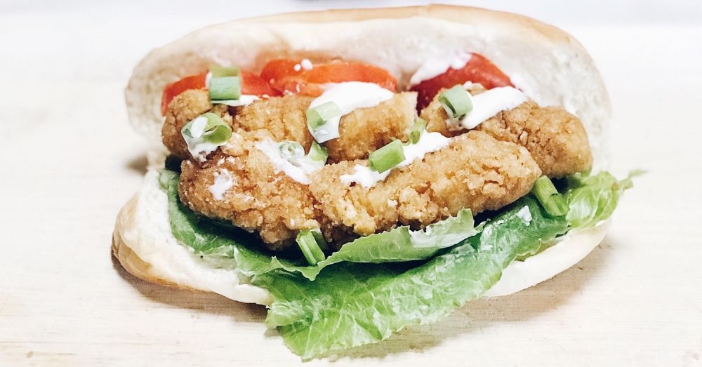 Crispy chicken strips layered on a sub roll with a lemon mayo sauce, lettuce, tomato and green onion.