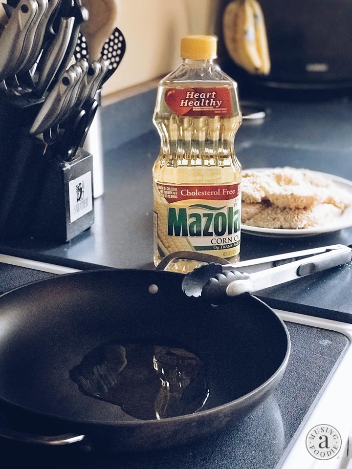Mazola Corn Oil warming in a skillet on the stove.