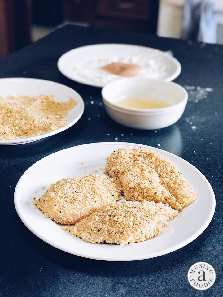 Panko crusted chicken breasts ready to be seared in a skillet.