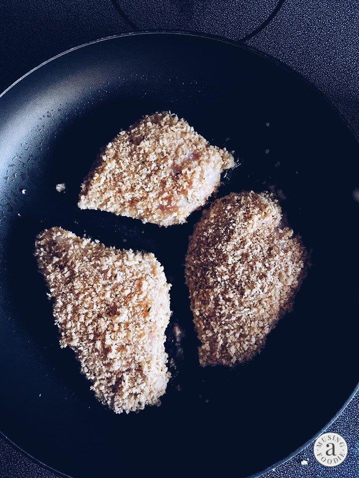 Panko crusted chicken searing in a skillet.